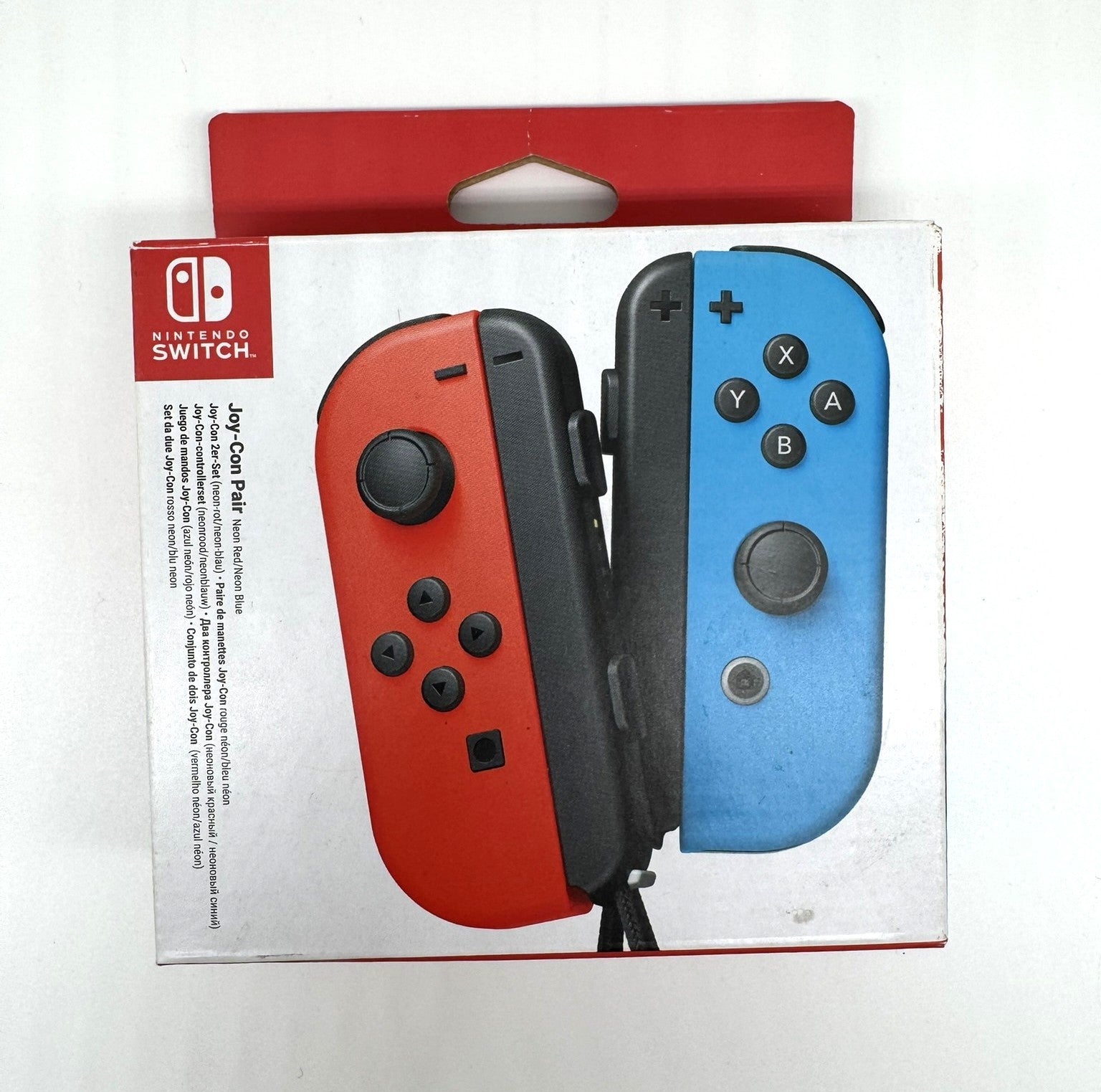 Verpackung eines Joy-Con Controller-Paares in Neon Rot und Neon Blau für Nintendo Switch. Die Joy-Cons sind prominent auf der Frontseite der Verpackung abgebildet.