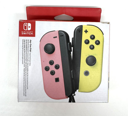 Verpackung eines Nintendo Switch Joy-Con Sets mit zwei unterschiedlich farbigen Controllern – links rosa, rechts gelb. Die Vorderseite zeigt die typische Nintendo-Verpackung mit weißer Fläche und rotem Griffbereich.