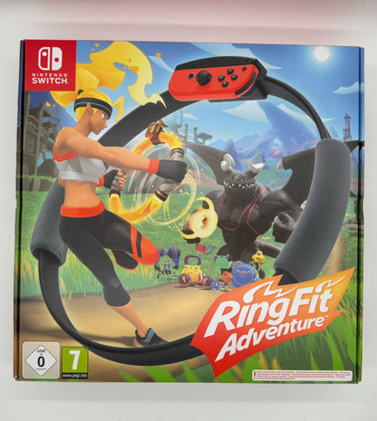 Verpackung von „Ring Fit Adventure“ für Nintendo Switch. Im Vordergrund eine sportliche Spielfigur mit einem Trainingsring (Ring-Con), der an einen Fitnessreifen erinnert. Im Hintergrund eine bunte Fantasiewelt mit Monstern. Ein Fitnessspiel, das körperliche Aktivität mit Rollenspiel-Elementen kombiniert. USK 0.